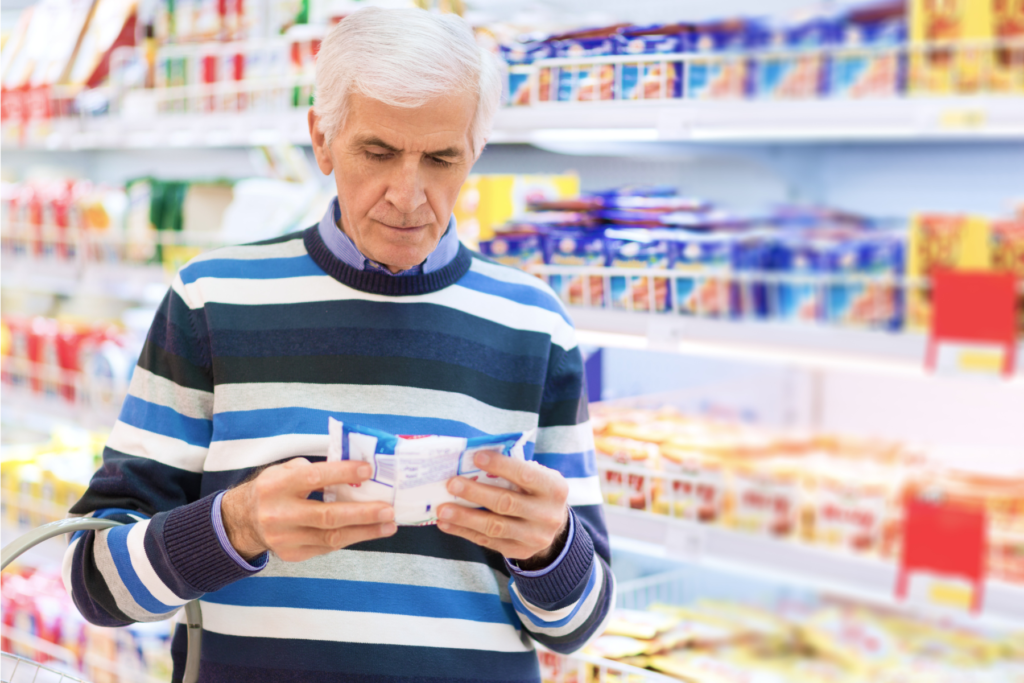 Man examining a packet of mozzarella in a supermarket